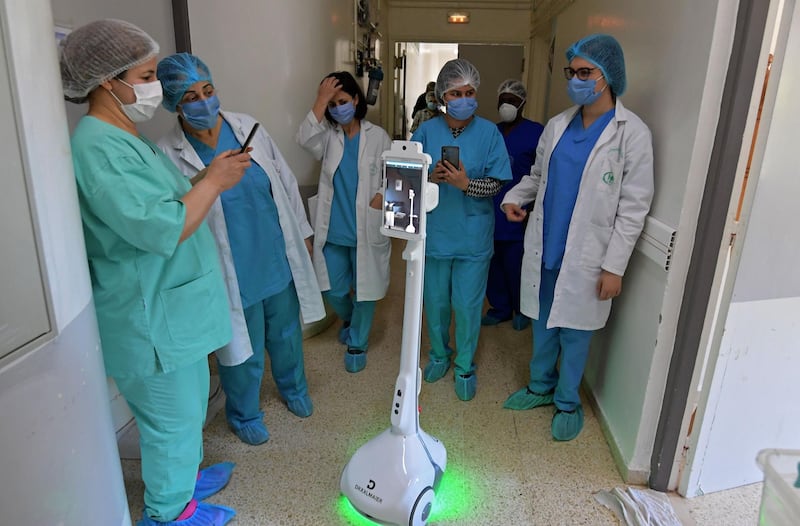 The medical staff at the Mami hospital interact with a robot, manufactured by a Tunisian company and donated to the hospital to support their efforts in combatting the coronavirus.  AFP