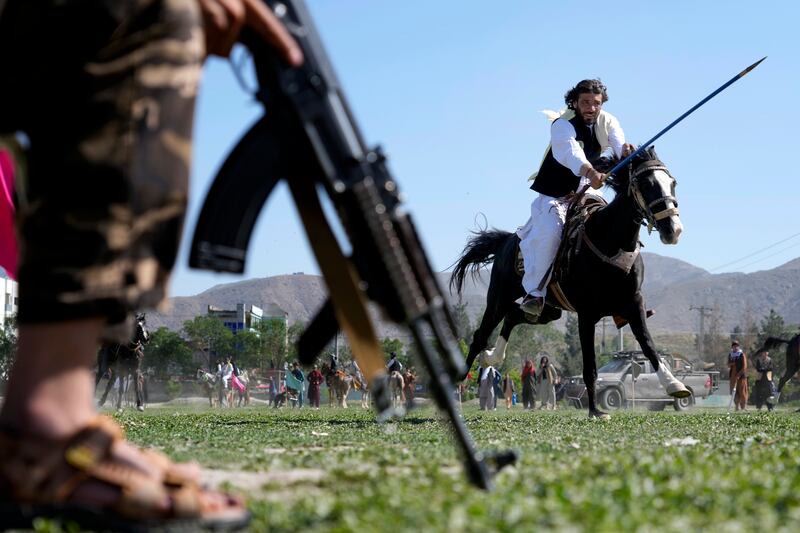 An Afghan horseman rushes to the target during a spear racing contest in Kabul's sprawling Chaman-e-Huzori park. AP