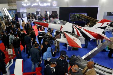 Visitors surround a training plane at the Egyptian booth during the first arms fair organized in Cairo. AP