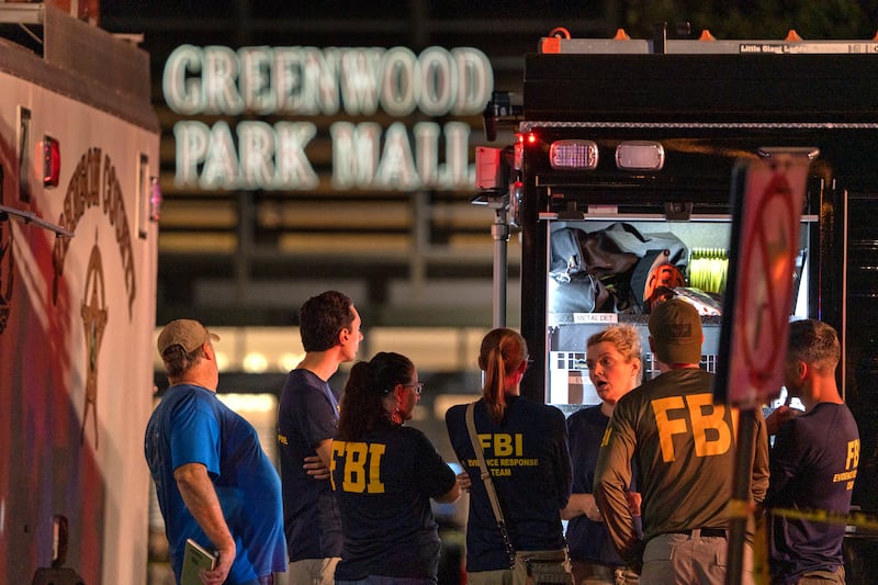 FBI agents gather at the scene of the shooting, where three people were killed while two were wounded after a man with a rifle opened fire in a food court. AP