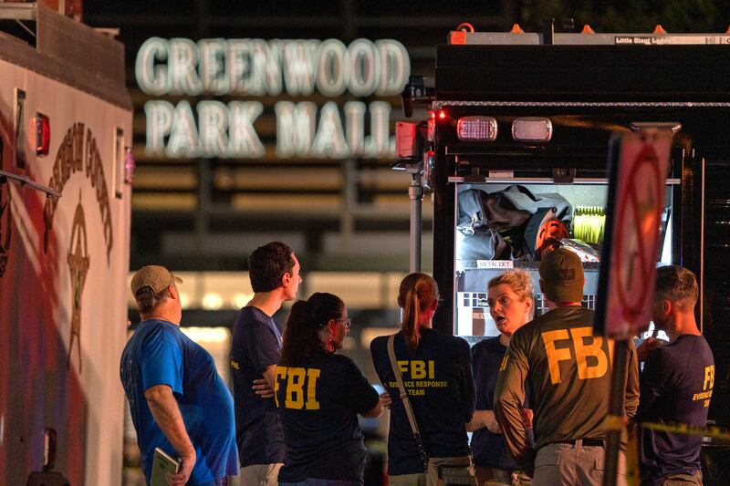 FBI agents gather at the scene of the shooting, where three people were killed while two were wounded after a man with a rifle opened fire in a food court. AP