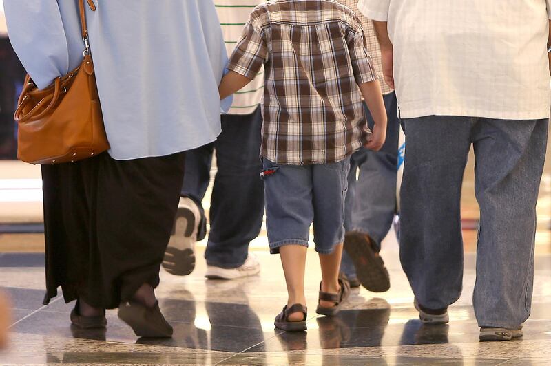 DUBAI , UNITED ARAB EMIRATES – July 19 , 2014 : Overweight kids with their parents at Mall of the Emirates in Dubai. ( Pawan Singh / The National ) For News.
