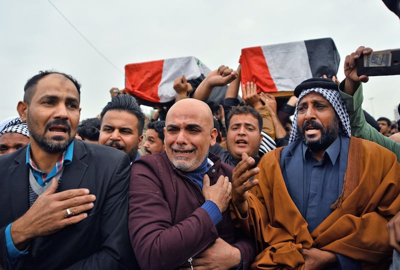 Iraqi mourners react during a funeral procession for anti-government demonstrators killed during protests a day earlier, in the central holy shrine city of Najaf on November 29, 2019. Nearly 45 people were reportedly killed and hundreds wounded across Iraq yesterday, at least 16 of them in Najaf, a day after the torching of Iran's consulate there.  / AFP / Haidar HAMDANI
