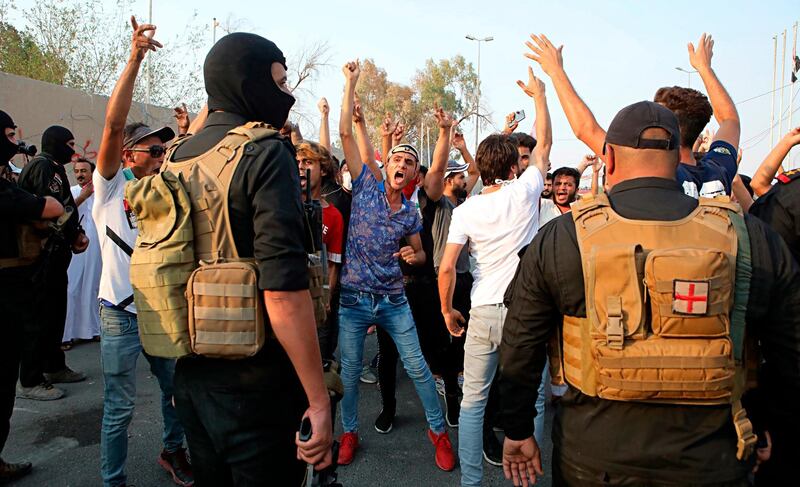 Protesters chant anti government slogans while security forces prevent them from storming the governor's building in Basra. AP Photo