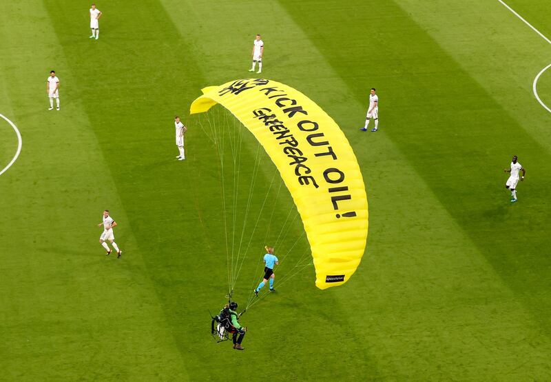 The German players look on as a Greenpeace paraglider lands in the Allianz Arena stadium in Munich. AP Photo