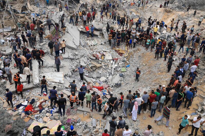 Civilians and rescuers look for survivors in the rubble of a building after Israeli bombing of Khan Younis in the southern Gaza Strip on November 12, 2023. AFP