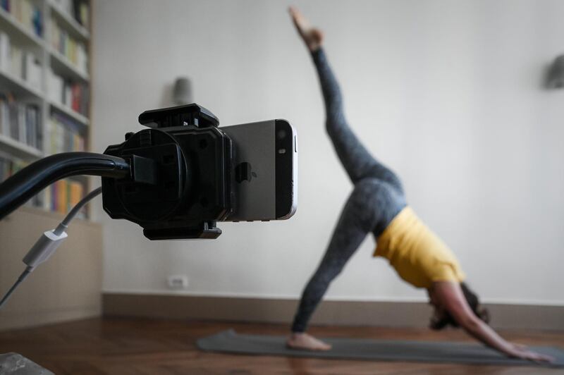 A yoga teacher rehearses prior to teaching a streamed live class on her Instagram account in Paris on April 4, 2020, on the nineteenth day of a lockdown in France aimed at curbing the spread of the COVID-19 infection caused by the novel coronavirus. / AFP / Philippe LOPEZ
