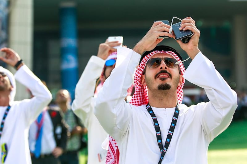 Visitors take footage of aerial displays during opening day of the Dubai Airshow. Victor Besa for The National