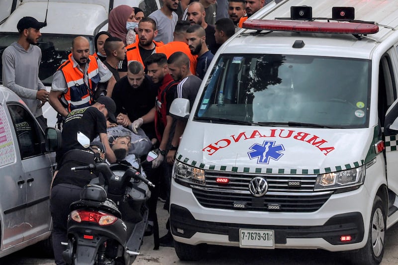 Paramedics carry an injured man from an ambulance. AFP