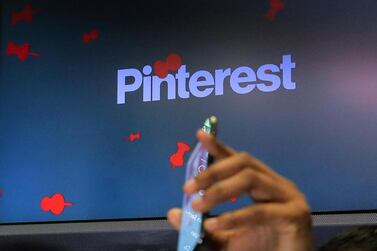 A guest holds up a phone during the Pinterest IPO on the floor of the New York Stock Exchange on April 18, last year. Reuters