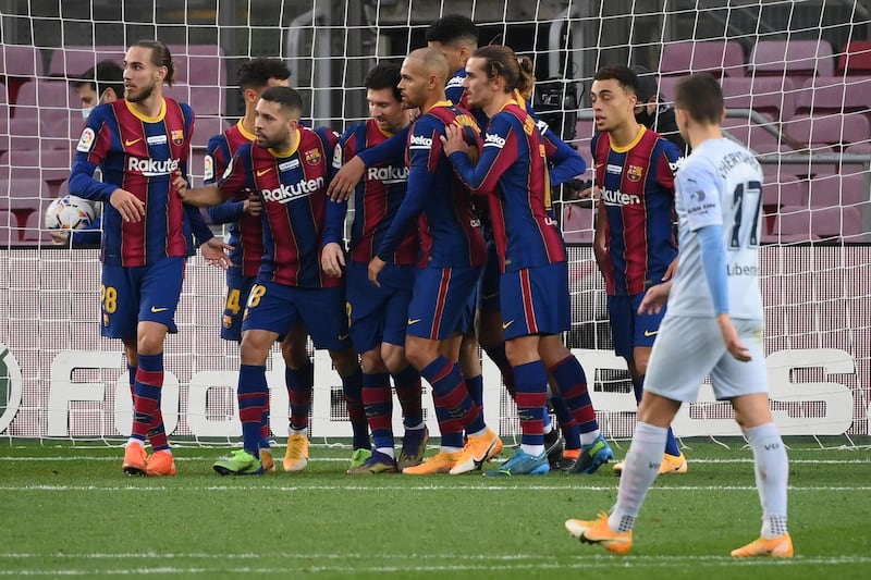 Lionel Messi is congratulated by Barcelona teammates after scoring the goal against Valencia that saw him pull level with Pele's record for most goals for a single club. AFP