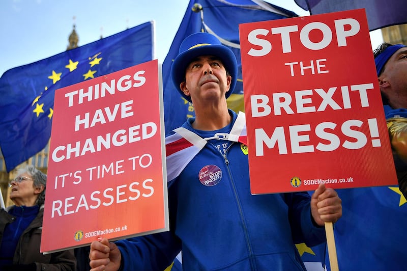 Pro-European Union (EU), anti-Brexit demonstrator Steve Bray holds placards and wave Union and EU flags as they protest outside of the Houses of Parliament in London on November 14, 2018. - British and European Union negotiators have reached a draft agreement on Brexit, Prime Minister Theresa May's office said on November 13. (Photo by Ben STANSALL / AFP)