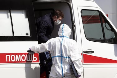 A medical specialist wearing a protective suit escorts a patient to a hospital complex for patients with the Covid-19 disease in Russia. EPA