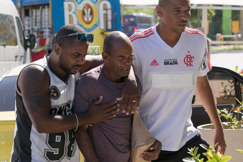 Sebastiao Rodrigues, center, uncle of the the young soccer player Samuel Rosa, one of the victims of a fire at a Brazilian soccer academy, grieves as he enter at a hotel in Rio de Janeiro, Brazil. A fire early Friday swept through the sleeping quarters of an academy for Brazil's popular professional soccer club Flamengo, killing 10 people and injuring three, most likely teenage players, authorities said. AP Photo