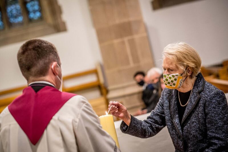 Pat Hume, right, lights a candle at St Eugene's Cathedral. Getty Images