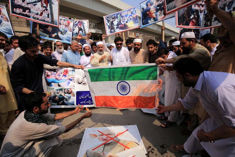 People burn an Indian flag during a protest in Peshawar, Pakistan.  EPA