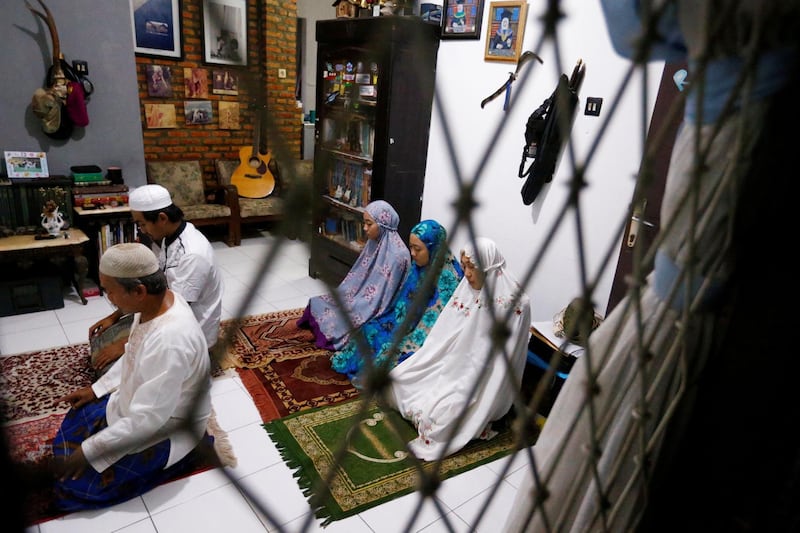 Tatan Agustustani, a 52-year-old Muslim man, prays with his family inside their house in Bogor, near Jakarta, Indonesia. Reuters