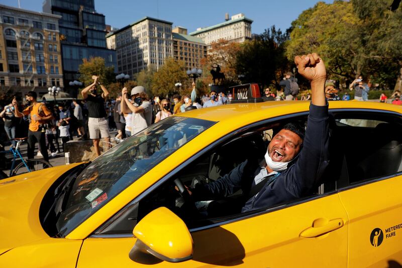 A cab driver raises his fist as people celebrate media announcing that Democratic US presidential nominee Joe Biden has won the 2020 US presidential election on Union Square in the Manhattan borough of New York City, on November 7, 2020. Reuters