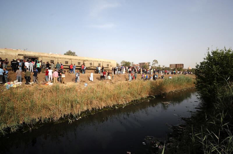 People gather at the site where train carriages derailed in Qalioubia province, north of Cairo, Egypt. Reuters