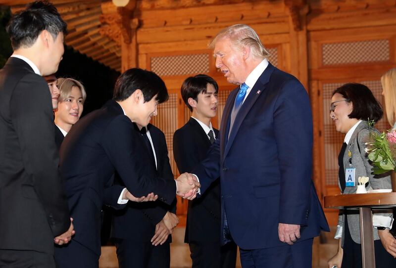 US President Donald J. Trump shakes hands with a member of South Korean boy group Exo during his visit to the South Korean presidential office Cheong Wa Dae in Seoul to attend a welcome dinner hosted by President Moon Jae-in. EPA