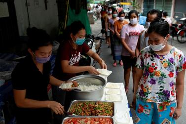 Volunteers give free food to migrant workers from Myanmar who lost their jobs following the coronavirus disease outbreak in Bangkok, Thailand. Reuters