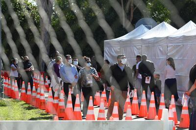 CORRECTION / People wait in long lines for coronavius tests at a walk-up Covid-19 testing site, November 24, 2020, in San Fernando, California, just northeast of the city of Los Angeles. California shattered the state's single-day COVID-19 record with over 20,500 new cases recorded on November 23 ahead of the Thanksgiving holiday. / AFP / Robyn Beck
