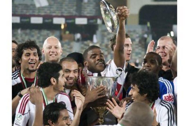 Al Jazira players crowd around to touch the President's Cup in a moment that will go down in the club's history.