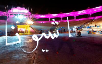 Artist Karim Jabbari writes 'The National' in Arabic using light calligraphy during the ART FOR ALL Community Week at Khalifa Park, Abu Dhabi on the 19th October 2012. Credit: Jake Badger for The National


