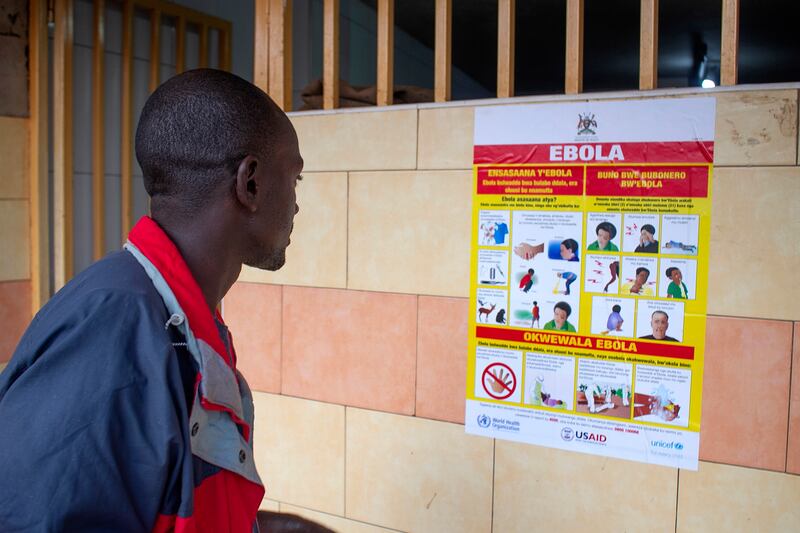 A man studies an Ebola awareness campaign poster after an outbreak of the disease. Kampala, Uganda, September 28, 2022. EPA