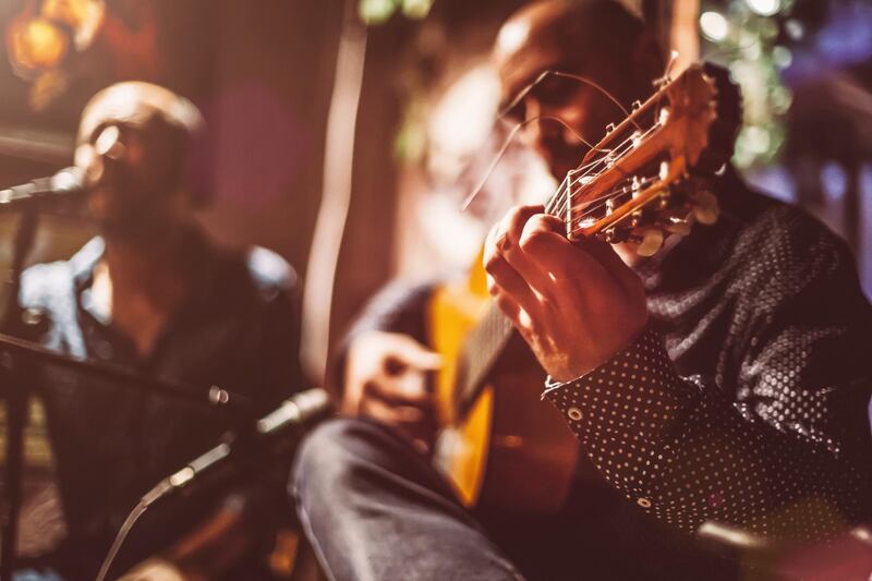 Two male musicians on a stage performing traditional flamenco music. Getty Images