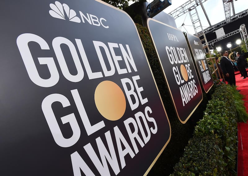 FILE - Event signage appears above the red carpet at the 77th annual Golden Globe Awards, on Jan. 5, 2020, in Beverly Hills, Calif. The 78th annual Golden Globes will be held on Sunday, Feb. 18, 2021. (Photo by Jordan Strauss/Invision/AP, File)