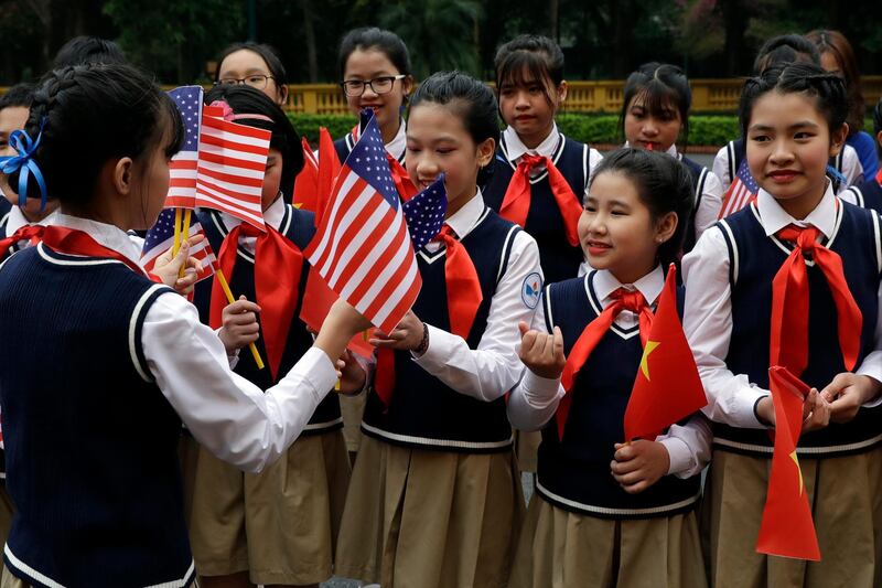 Children are handed flags before President Donald Trump arrives to meet with Vietnamese President Nguyen Phu Trong at the Presidential Palace in Hanoi. AP Photo