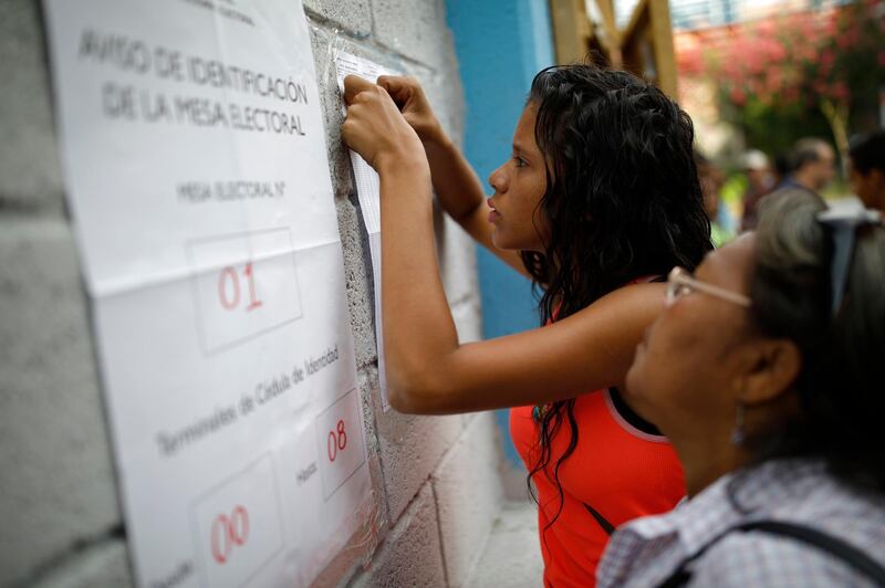 Venezuelan citizens check electoral lists at a polling station during the presidential election in Caracas, Venezuela. Carlos Garcia Rawlins / Reuters