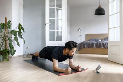 Photo series of a japanese man working out at home, watching youtube videos and learning the exercises.