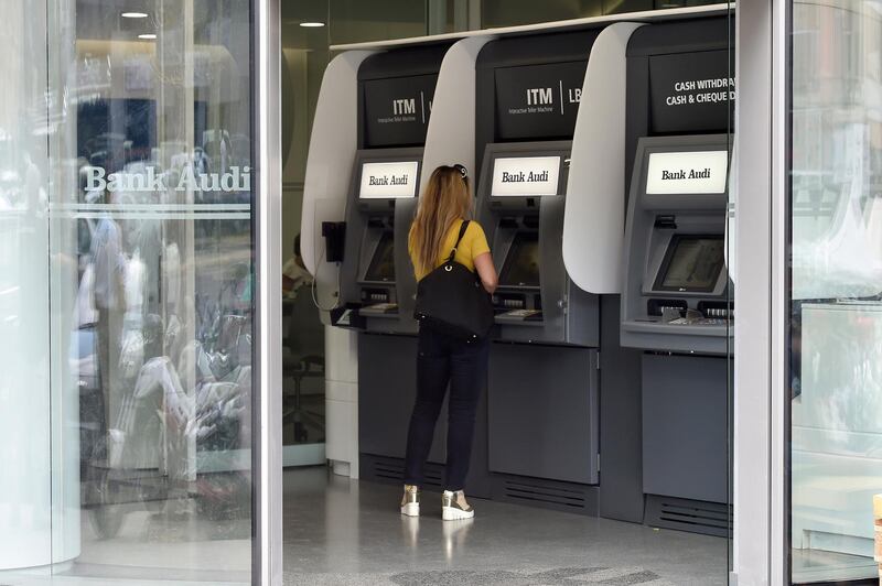 A woman uses an ATM at a local bank in Beirut, Lebanon. EPA