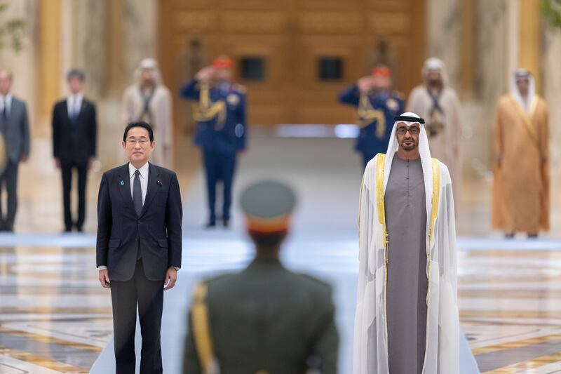 Sheikh Mohamed and Mr Kishida stand for the UAE national anthem. Abdulla Al Neyadi / Presidential Court