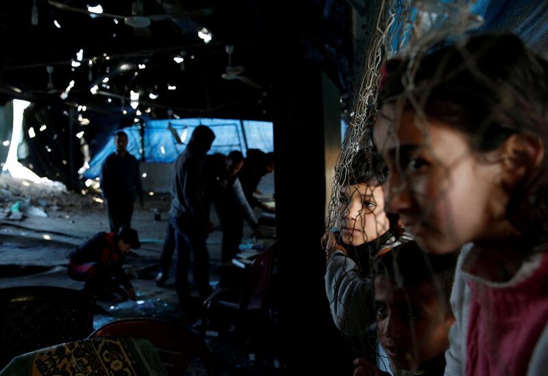 Palestinian boys watch as others inspect a mosque that was damaged in a nearby Israeli air strike. Reuters