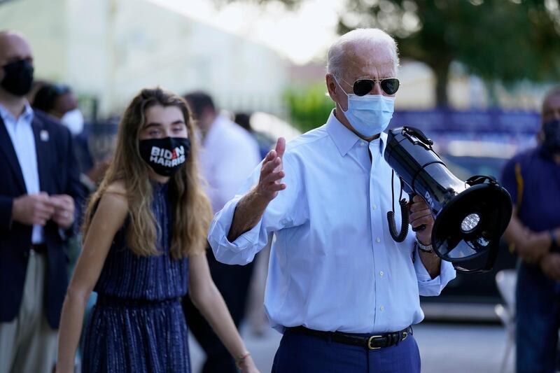 Democratic presidential candidate former Vice President Joe Biden, accompanied by his granddaughter Natalie Biden, speaks to people outside a campaign victory center, Thursday, Oct. 29, 2020, in Fort Lauderdale, Fla. (AP Photo/Andrew Harnik)