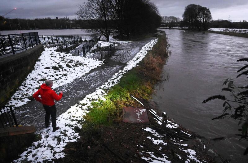 A council inspector examines a bridge and checks the water level on the River Mersey in Didsbury. AFP
