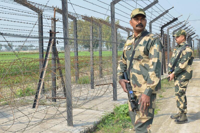 Indian Border Security Force personnel walk along a fence at the India Pakistan border on the outskirts of Amritsar. AFP