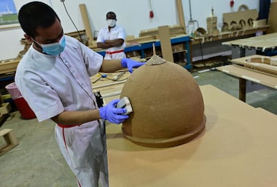 An inmate wearing protective gear amid the COVID-19 pandemic works on a 1:60 scale reproduction of Abu Dhabi's Sheikh Zayed Grand Mosque, at the Al-Awir central Prison in Dubai, in the United Arab Emirates, on May 21, 2020. In the correctional compound located about 35 Km. from Dubai's city centre, the use of video conferencing systems is one of the ways the authorities are trying to prevent the spread of the COVID-19 respiratory disease in prison, along with an array of safety measures which have been difficult on inmates, some of whom spent their days in workshops and recreational classes. / AFP / GIUSEPPE CACACE
