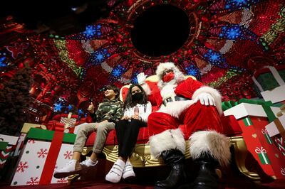 Santa poses for a picture with kids during the official Expo 2020  Christmas Tree Lighting ceremony in Dubai. REUTERS / Satish Kumar