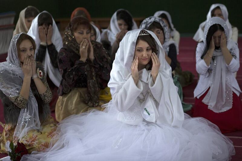 Sera Aliyeva, centre, surrounded by her relatives and friend, prays during wedding in a mosque in Sary-Su, Crimea. Crimea’s 300,000 Tatar Muslims feel particularly vulnerable because of their tenuous hold on the homes and land they inhabit. Alexander Zemlianichenko / AP Photo