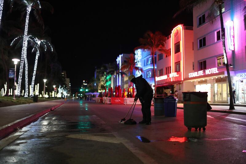 A city employee cleans up on Ocean Drive after people left due to an 8pm curfew on March 21, 2021 in Miami Beach, Florida. College students have arrived in the South Florida area for the annual spring break ritual, prompting city officials to impose an 8pm to 6am curfew as the coronavirus pandemic continues. Getty Images/AFP