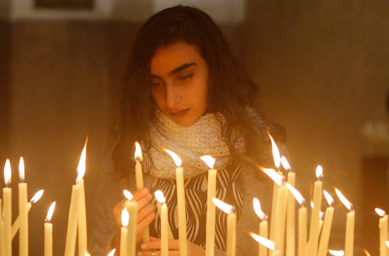 An Egyptian Catholic woman lights candle during a mass on Christmas eve at Saint Joseph's Roman Catholic Church in Cairo, Egypt. Amr Abdallah Dalsh / Reuters.