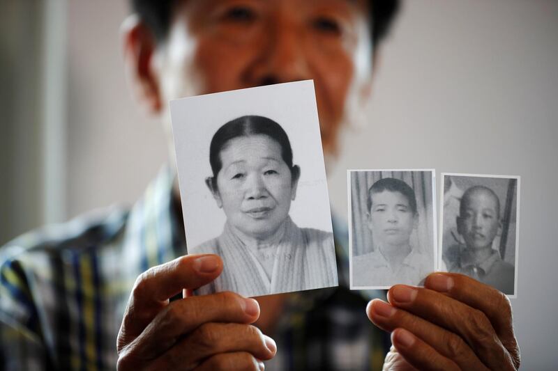 A man selected as a participant for a reunion shows pictures of his deceased mother and little brothers living in North Korea, at a hotel used as a waiting place in Sokcho, South Korea. Reuters