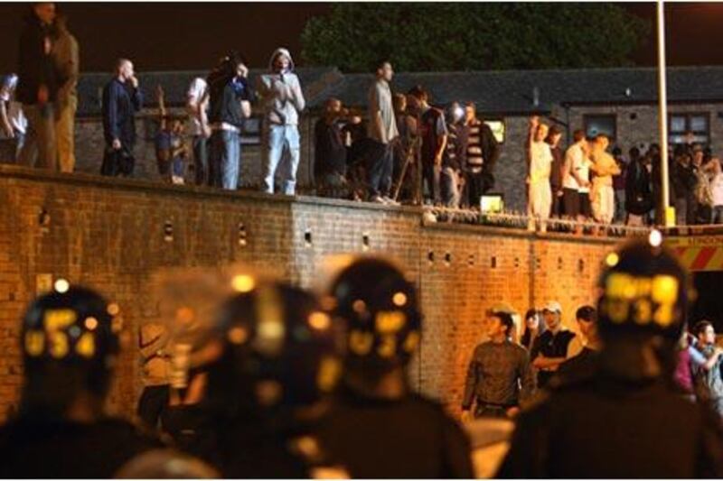 Riot police officers and supporters outside Upton Park last night. A fan was stabbed during large scale violence before the League Cup second round clash between West Ham and Millwall, while the match was interrupted by a pitch invasion.