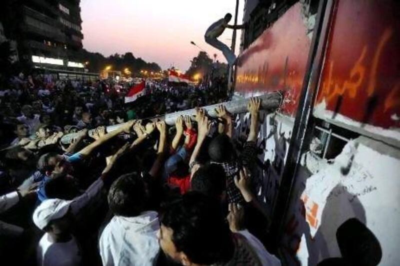 Egyptian protesters try to dismantle and climb over a concrete wall in front of the Israeli Embassy in Cairo last year. Mohamed Omar / EPA