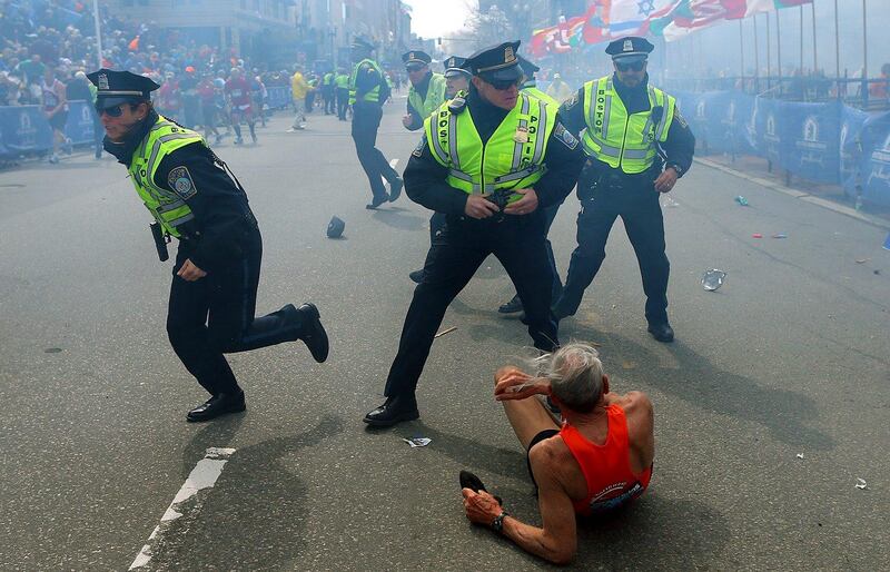 ADDS IDENTIFICATION OF RUNNER- BILL IFFRIG- Bill Iffrig, 78, lies on the ground as police officers react to a second explosion at the finish line of the Boston Marathon in Boston, Monday, April 15, 2013. Iffrig, of Lake Stevens, Wash., was running his third Boston Marathon and near the finish line when he was knocked down by one of two bomb blasts. (AP Photo/The Boston Globe,  John Tlumacki) *** Local Caption ***  ADDITION Boston Marathon Explosions.JPEG-005da.jpg