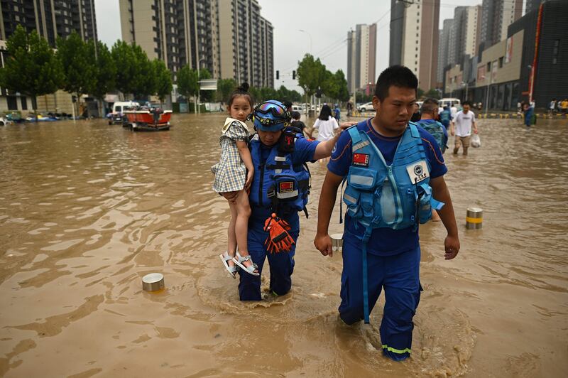 Members of the Blue Sky rescue team carry a girl to safety.